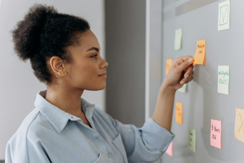 femme contente decroche un post it sur mur