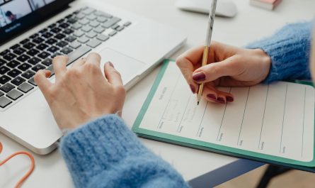 femme qui travail sur ordinateur et note son planner hebdomadaire