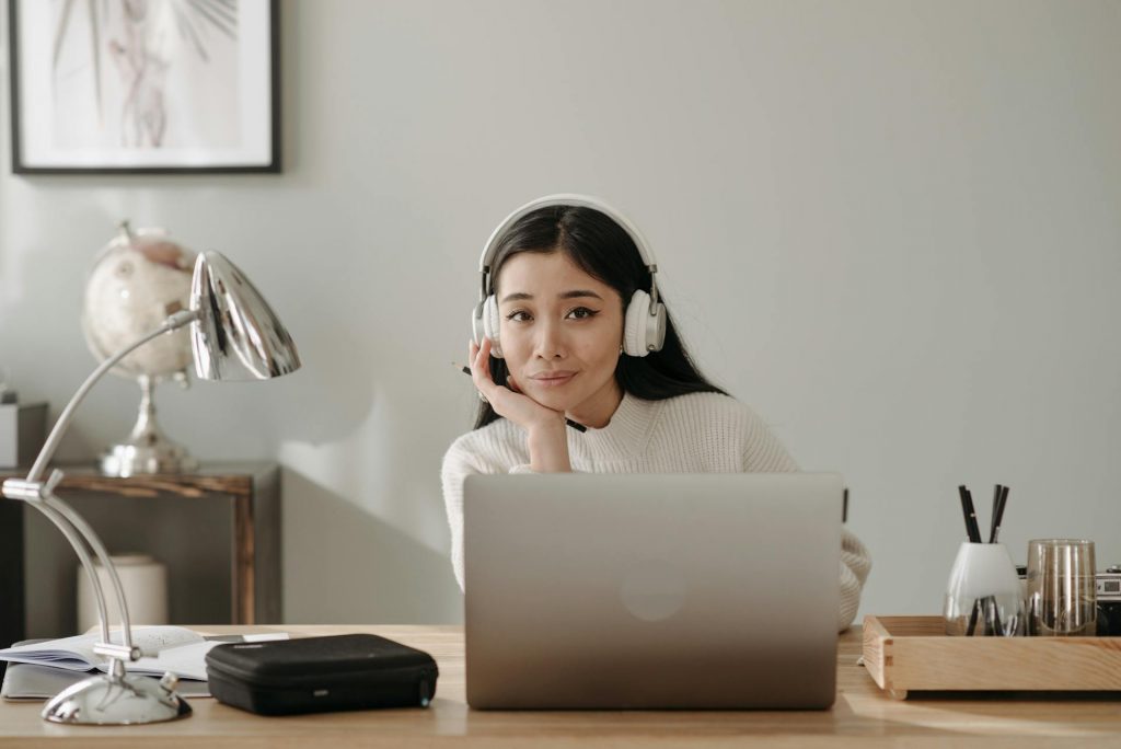 femme travail sur bureau et ecoute musique casques